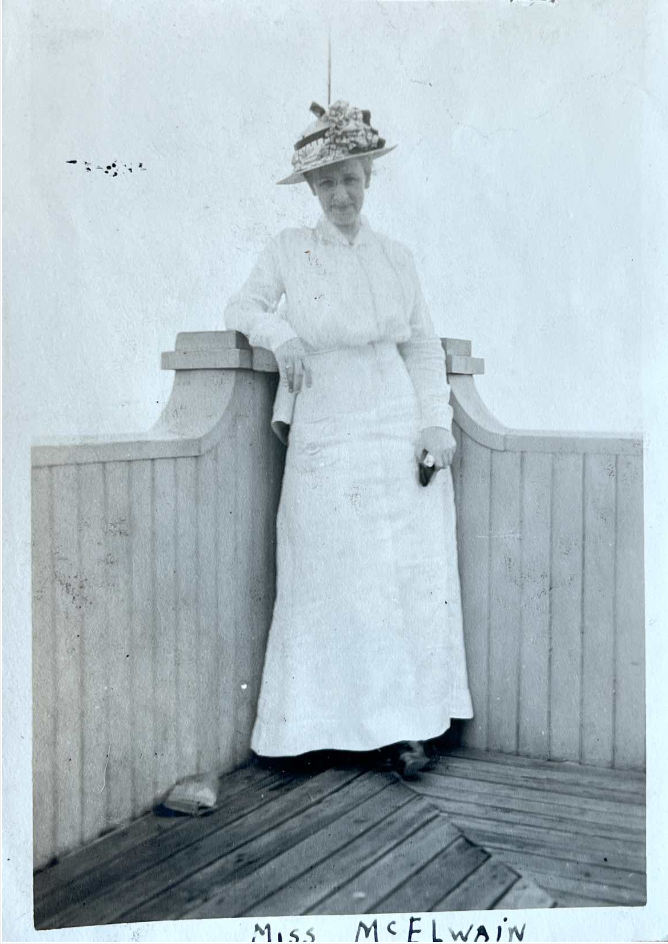 Mary McElwain in a white dress standing on a deck