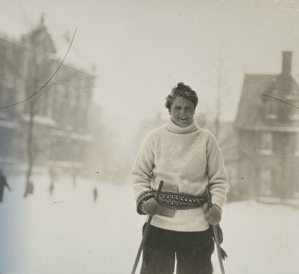 Photo of Frances dressed in winter clothes and holding poles in front of what appears to be Seelye in the winter.