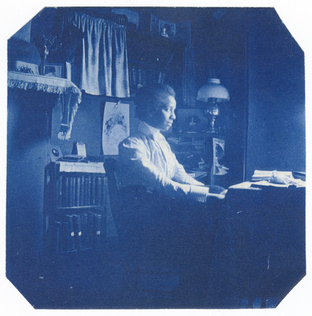 Black and white photograph of Otelia Cromwell taken at her desk in 1900.