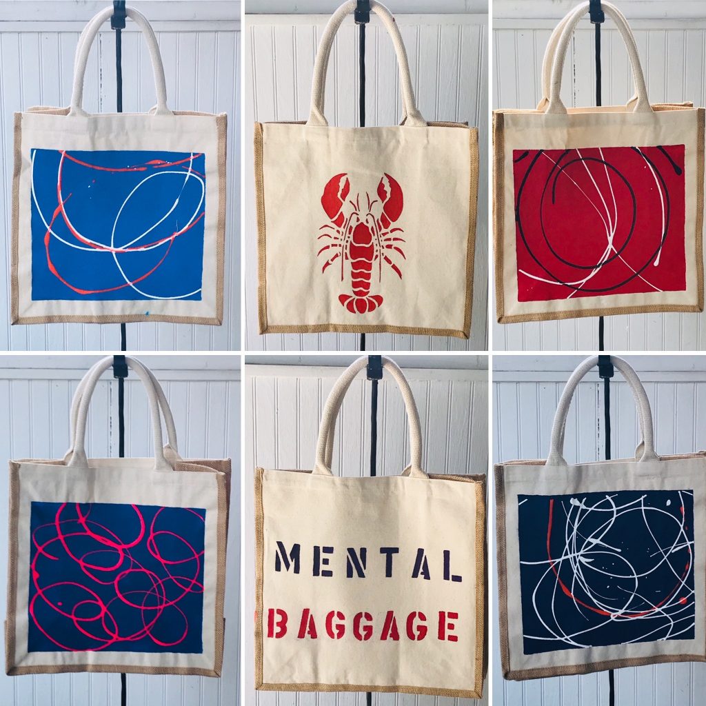 Six tote bags, four with abstract art, one with a lobster and one with the saying "mental baggage"