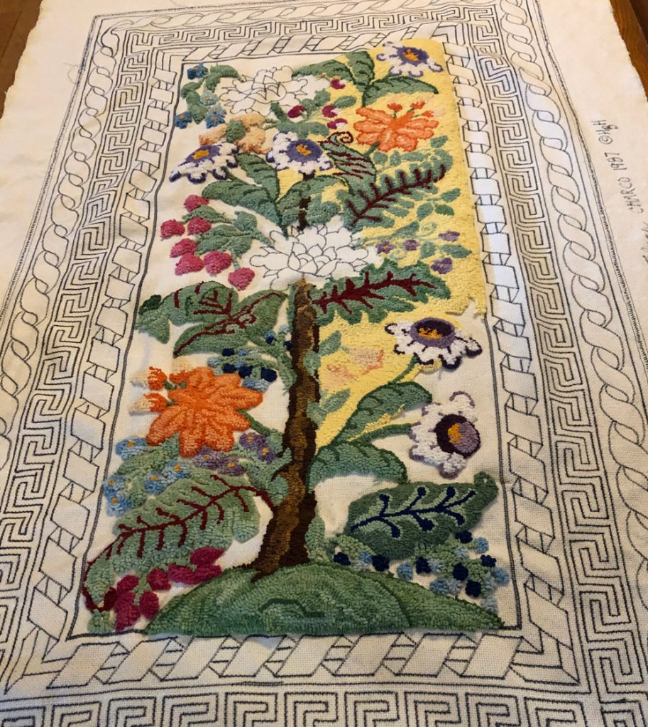 flowers wrapped around a tree, in a rug hooking design