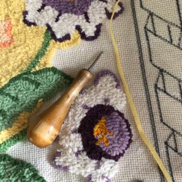 rug hooking tool on partially completed flowers