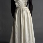 A maid's apron from 1895-1905. Maids were often the faces of a home, because they opened the door to greet visitors. They had to look presentable, while also wearing clothes that could get dirty while cleaning. This made aprons an essential part of a maid’s wardrobe. An apron could be removed to reveal a clean dress underneath.