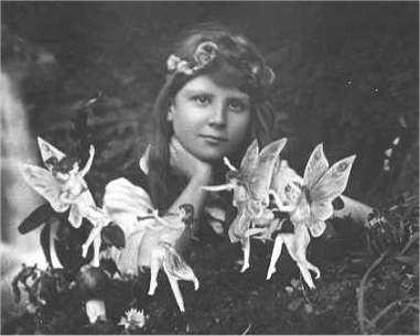 Frances Griffith with fairies dancing in front of her.