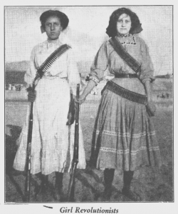 image of two women holding gun and wearing ammo. Caption reads "girl revolutionists"