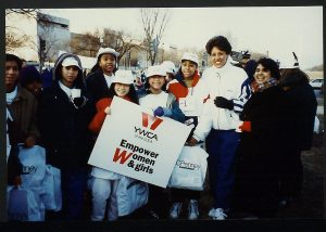 image of YWCA women holding a sign that reads "YWCA Empower women and girls"