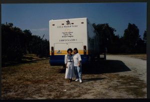 two women standing in front of a mammography bus