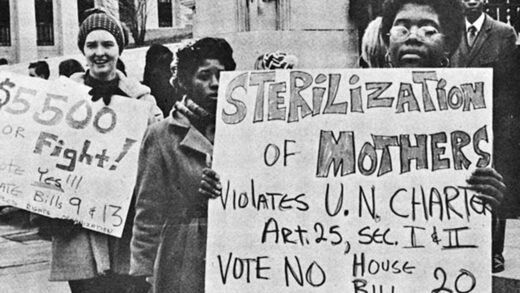 A group of women in at a protest against forced sterilization. One woman is holding a poster that says "sterilization of Mothers violates U.N. Charter Art. 25, Sec I & II Vote Mo House Bill 20.