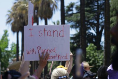 A group of people holding signs in support of Planned Parenthood.