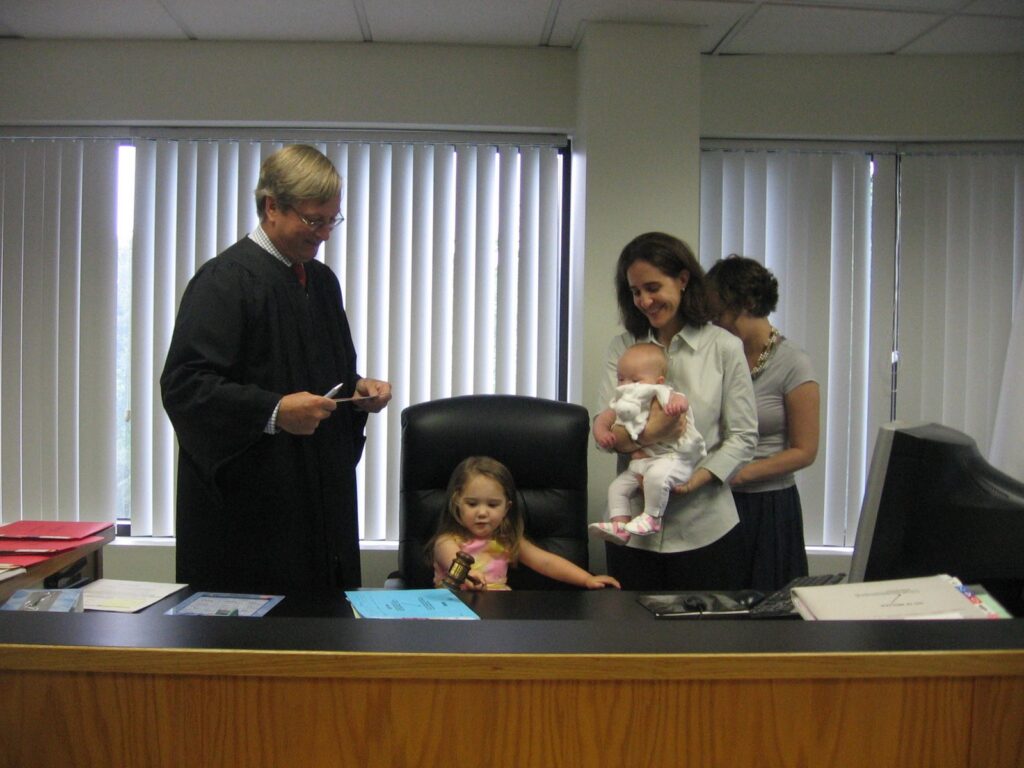 Toddler aged Lucia banging a gavel at a judge's desk