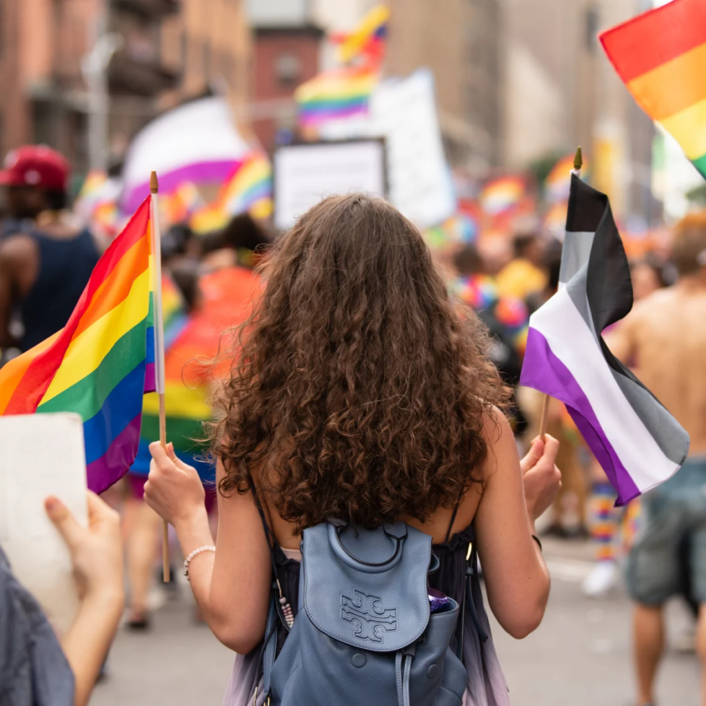 A woman carries the rainbow flag and the asexual pride flag at the World Pride parade in New York on June 23