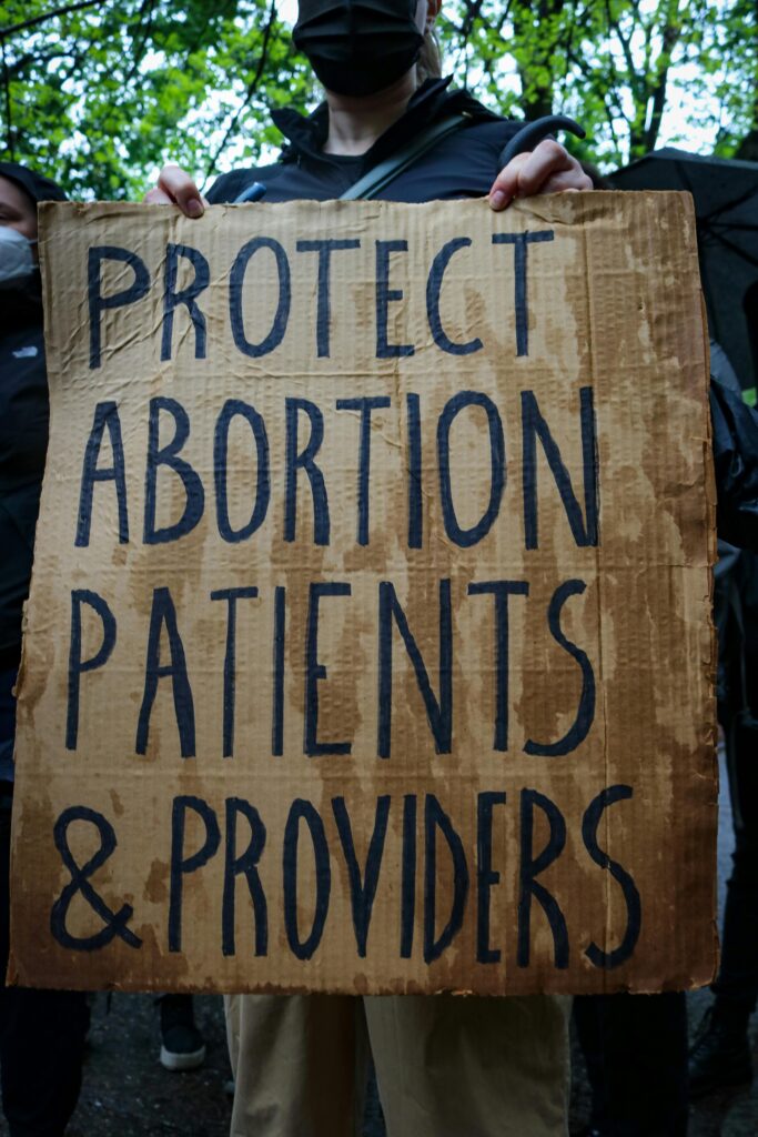 Protestor holding sign, which reads, "Protect abortion patients & providers."