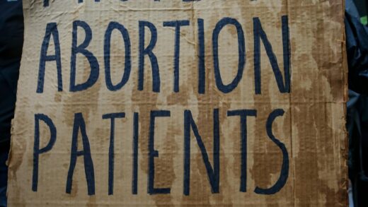 Protester holding sign. which reads, "Protect abortion patients and providers."