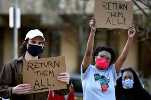 Image of two protesters at a protest over the collection of human remains by the Penn Museum.