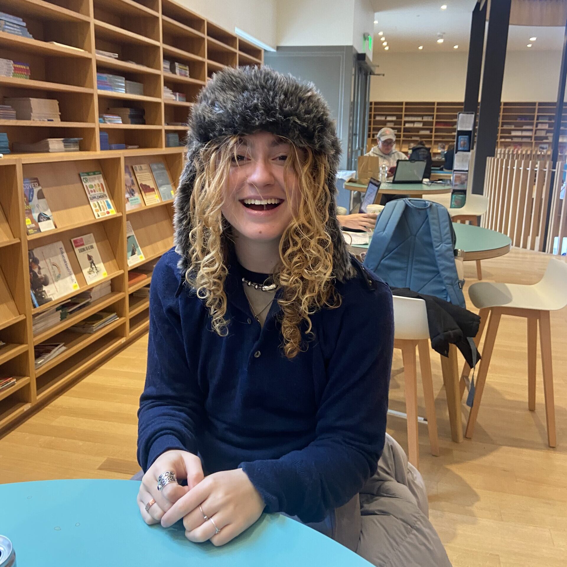 Madelyn Halperin '25 wears a fun fuzzy hat in Neilson Library. 