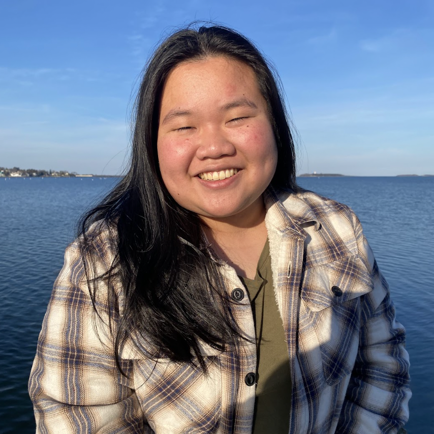 Jenny Yang '25 safely posing by an unknown ocean with a bright smile on her face! 