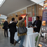Gina Ulysse raises her arm with excitement when she finds out she can get a conference poster. (Shana Sureck Photography)