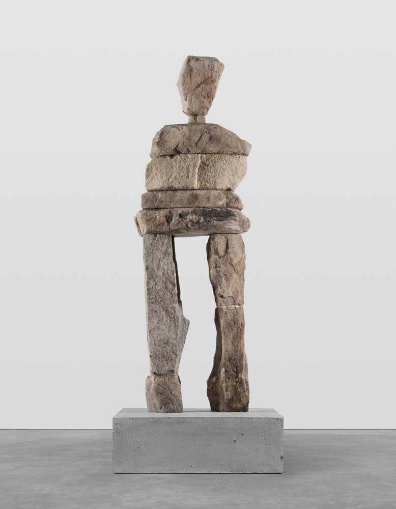 Stone humanoid statue entitled, "The Clever"