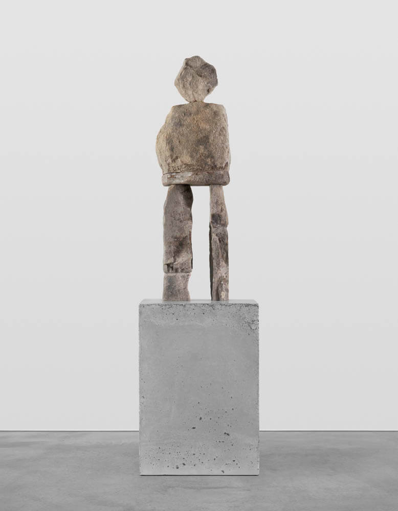 Stone humanoid statue entitled, "The Frisky"