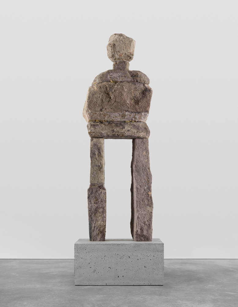 Stone humanoid statue entitled, "The Content"