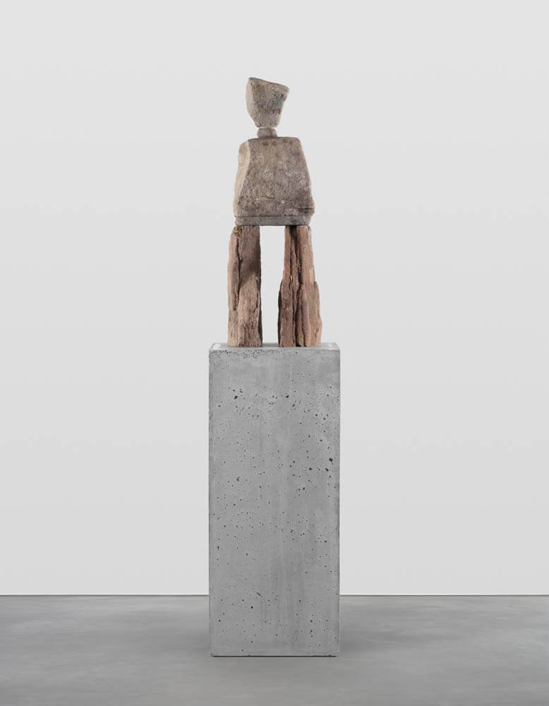 Stone humanoid statue entitled, "The Relaxed"