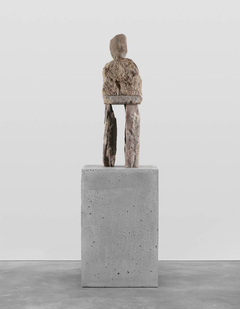 Stone humanoid statue entitled, "The Concerned"