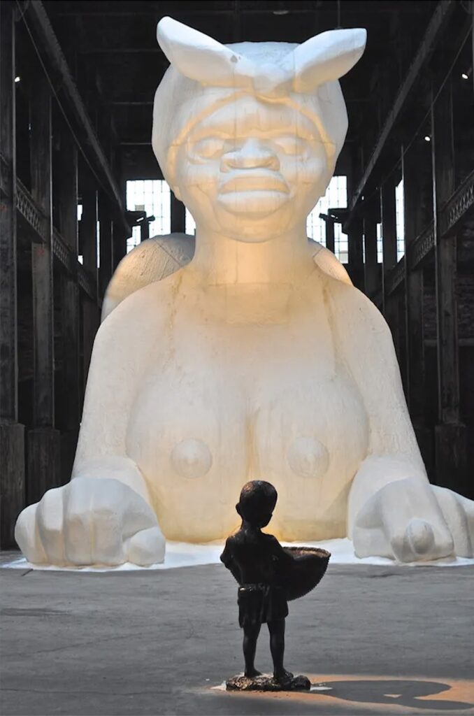 Sculptural Installation titled "A Subtlety" or "The Marvelous Sugar Baby, an Homage to the unpaid and overworked Artisans who have refined our Sweet tastes from the cane fields to the Kitchens of the New World on the Occasion of the demolition of the Domino Sugar Refining Plant" by Kara Walker