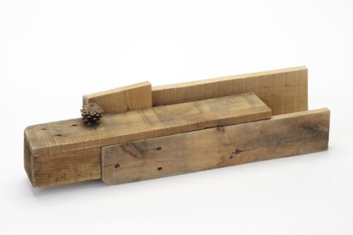 Long, irregular shape made with plywood, with a pinecone sitting on center rectangle.