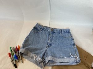 A pair of shorts, sharpies, and a piece of brown paper