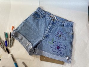 A pair of shorts with flowers drawn on them.
