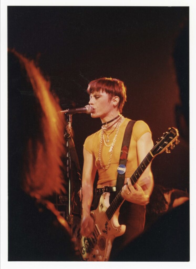 an action shot of Joan Jett playing a guitar and singing at Pearl Street Nightclub