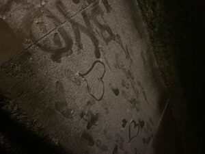 Students drawing in the snow on the sidewalk.