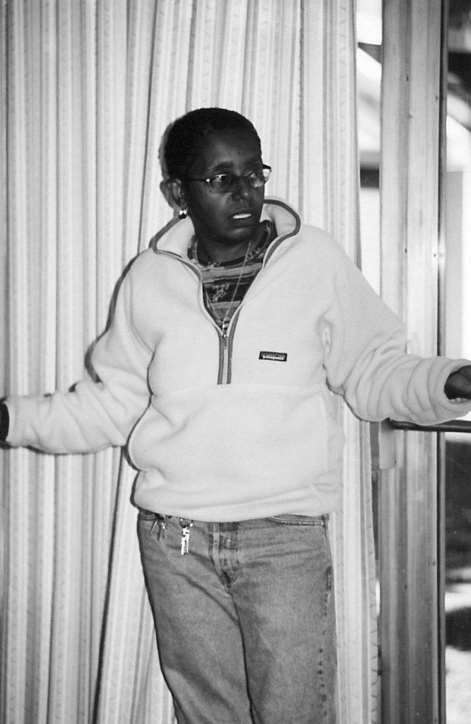 Black and white photo of a black person in a zip sweater