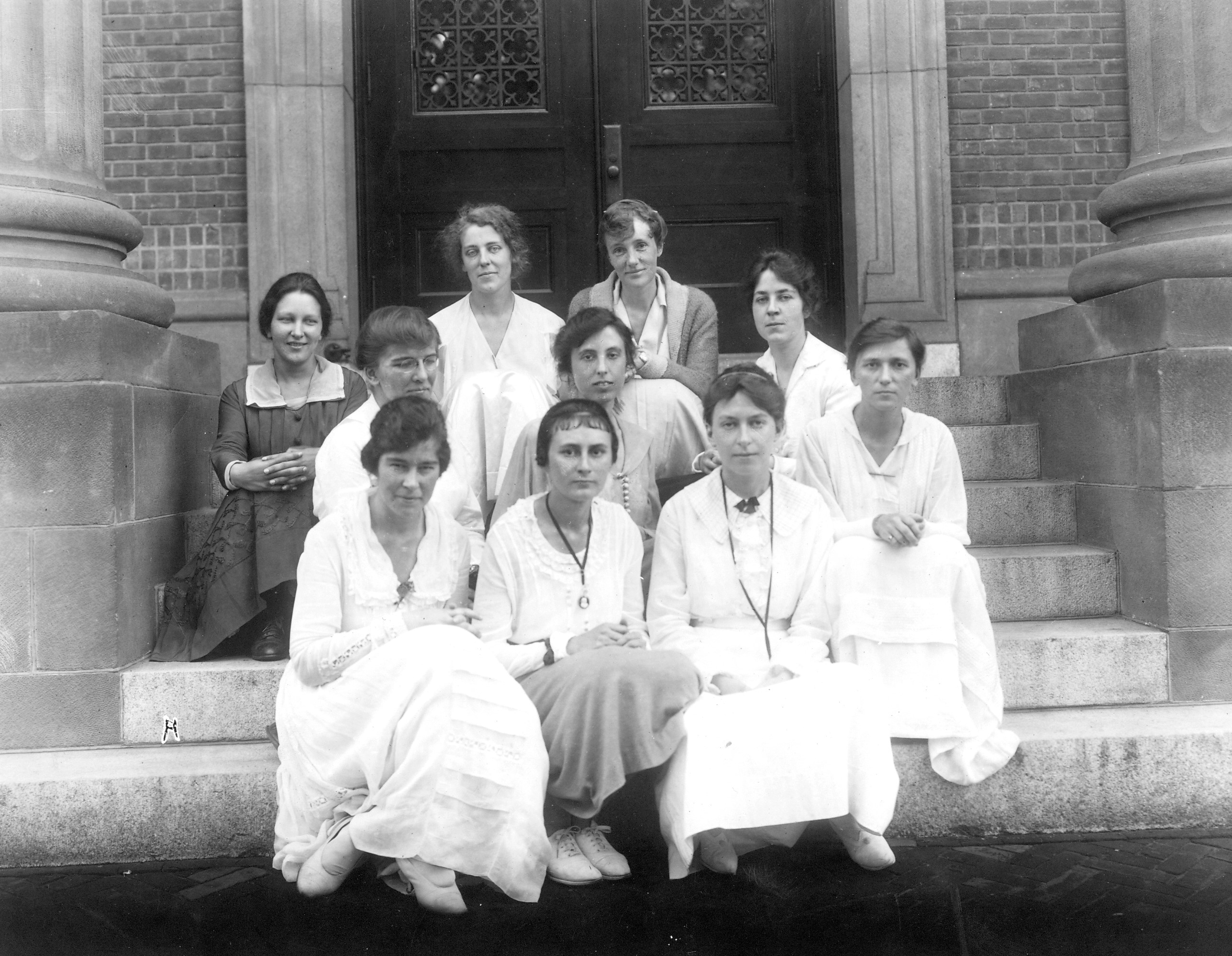 Black and white photo of ten women from the Smith School for Social Work, sitting on steps.